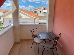 a small balcony with two chairs and a table at Guest House Lav in Primošten