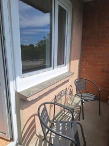 two chairs and a glass table on a balcony at Spacious & sunny apartment with a balcony in Tartu