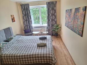 a bedroom with a bed with a checkered blanket at Spacious & sunny apartment with a balcony in Tartu