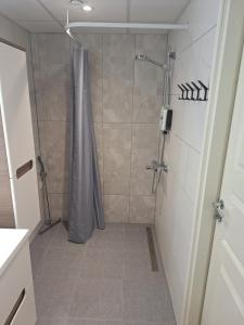 a shower with a shower curtain in a bathroom at Spacious & sunny apartment with a balcony in Tartu +4 photos