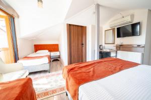 a hotel room with two beds and a tv at Şehrizade Konakları in Amasya