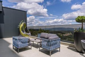 a patio with two chairs and a couch on a balcony at Horizont Aparthotel Jahorina in Jahorina