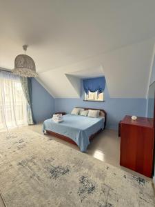 a bedroom with a bed with blue walls and a window at Двухэтажный коттедж с 2 апартаментами на озере in Dolinka +28 photos
