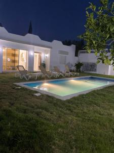 a villa with a swimming pool at night at Dar Emna in Hammamet +14 photos