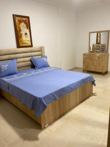 a bedroom with a bed with blue sheets and a mirror at Dar Emna in Hammamet
