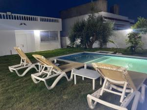 two chairs and a table next to a swimming pool at Dar Emna in Hammamet