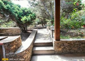a stone retaining wall with stairs in a garden at Villa Clelia in Stintino