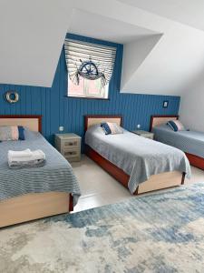 a bedroom with two beds and a window at Двухэтажный коттедж с 2 апартаментами на озере in Dolinka