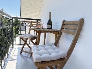 a chair and a table on a balcony with a bottle of wine at Двухэтажный коттедж с 2 апартаментами на озере in Dolinka