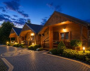 a log house with a driveway at night at Domki i Pokoje u Asi in Stegna
