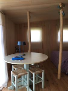 a table and two stools in a room with a bed at Les Jardins d'Yzorche in Saint-Bazile-de-la-Roche