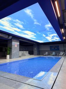 a large swimming pool in a building with a sky ceiling at Hills Managed by Dedeman in Erbil