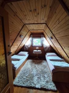 a attic room with two beds and a window at U Cecylii in Rowy