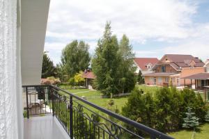 a balcony with a view of a house at Двухэтажный коттедж с 2 апартаментами на озере in Dolinka