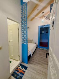 a small bedroom with a bed and a blue door at 燈塔情人歐風海景民宿 in Eluan