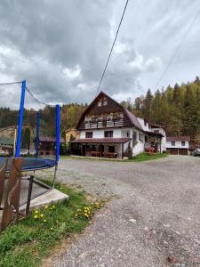 a large building with a playground in front of it at Cabana Dory și Dan in Arieşeni