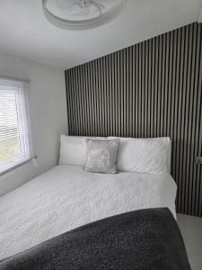 a bed with a pillow on it in a bedroom at Carlys Cosy Caravan in Cresswell