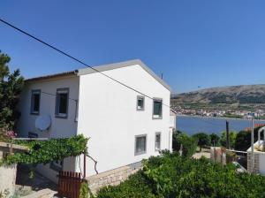 a white house with a view of the water at Aparmani Đani 2 in Pag