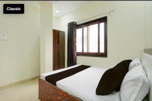 a bedroom with a large bed with a window at Tansen Guest House in Gwalior +3 photos
