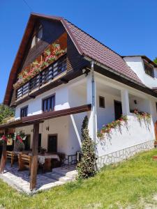 a house with flowers on the side of it at Cabana Dory și Dan in Arieşeni