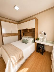 a bedroom with a large bed and a desk at Cantinho aconchegante in Londrina +22 photos