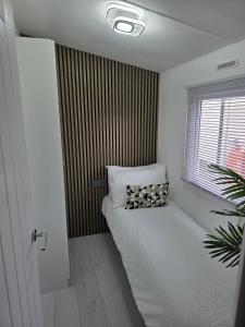 a room with a bed with a window and a pillow at Carlys Cosy Caravan in Cresswell +6 photos