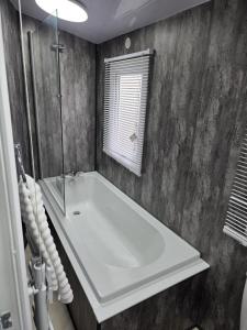 a bathroom with a white tub and a shower at Carlys Cosy Caravan in Cresswell