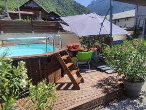 an umbrella on a deck next to a swimming pool at Studio en Abondance in Vacheresse +6 photos