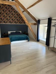 a bedroom with a bed and a wooden floor at Le Petit Moineau in Arthon