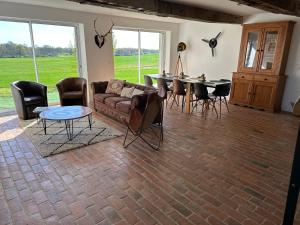 a living room with a couch and a table and chairs at Le Petit Moineau in Arthon