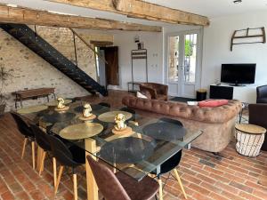 a living room with a table and a couch at Le Petit Moineau in Arthon