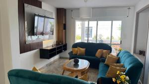a living room with two blue couches and a tv at Spacious villa, sea view in Cabo Negro