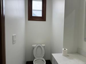 a white bathroom with a toilet and a window at Downtown Residance Room 2 in Guelph