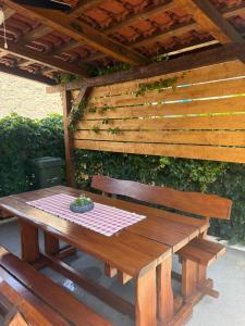 a wooden picnic table under a wooden roof at seafront HOUSE LALA Vinišće in Vinišće
