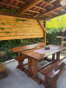 a wooden picnic table and bench under a wooden roof at seafront HOUSE LALA Vinišće in Vinišće +11 photos