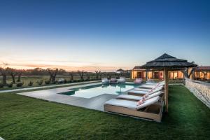 奥德赛克斯卡尔达农家乐的一个带躺椅和凉亭的游泳池