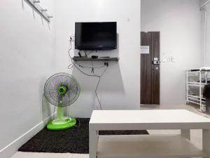 a living room with a fan and a tv at Maxi mama House in Bangkok