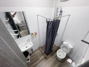 a bathroom with a black shower curtain and a toilet at Maxi mama House in Bangkok