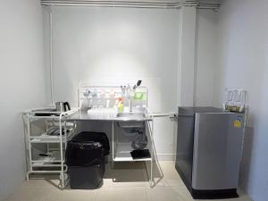 a bathroom with a sink and a refrigerator at Maxi mama House in Bangkok