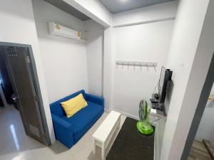 a small room with a blue couch and a tv at Maxi mama House in Bangkok
