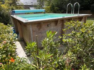 a swimming pool in the middle of a garden at IBI ENJOY la Suite in Ligné