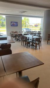 a dining room with tables and chairs in a restaurant at UMARI Reserva Hotel in Marituba