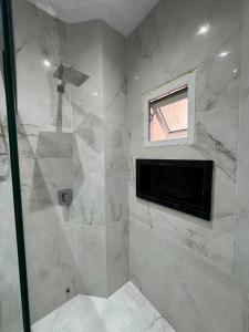 a bathroom with a shower with a television in it at UMARI Reserva Hotel in Marituba