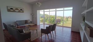 a living room with a table and chairs and a balcony at Casa Milor in Cabrafigal