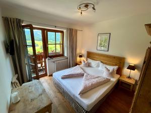 a bedroom with a bed with white sheets and pillows at Gasthof Kronreith in Maria Alm am Steinernen Meer