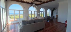 a living room with a couch and chairs and windows at Casa Milor in Cabrafigal