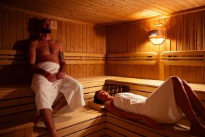 a man standing in a sauna with a man laying down at Hotel Paganella Andalo in Andalo +33 photos