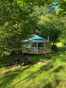 a gazebo with a blue tent in a yard at Les Jardins d'Yzorche in Saint-Bazile-de-la-Roche
