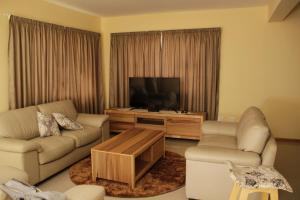 a living room with a couch and a flat screen tv at Monotoka Self Catering Apartments CC in Swakopmund