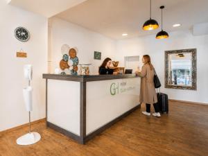 two women standing at the counter of a store at Hotel Gute Hoffnung Pforzheim in Pforzheim